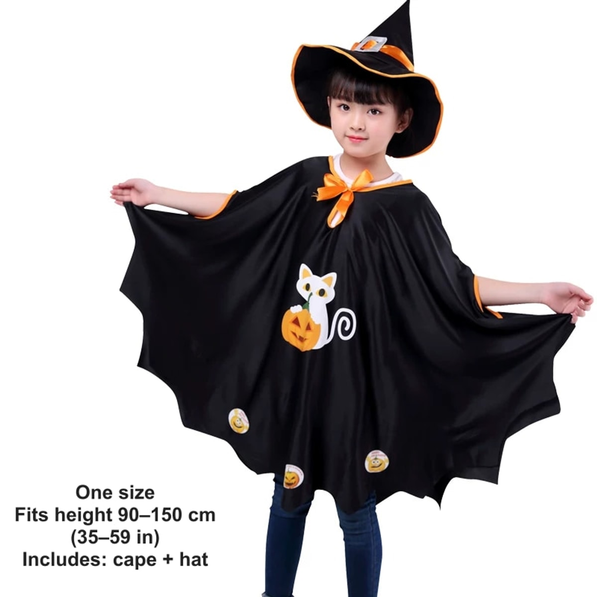 Child wearing the black kids' witch costume: bat-wing cape with orange bow and white cat & pumpkin print, plus a pointed witch hat