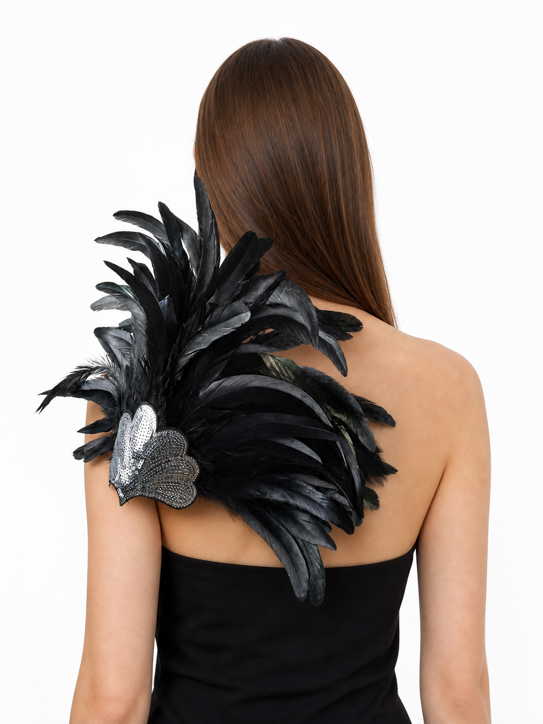 Back view of a woman wearing a black feather headpiece with a silver sequined heart on her shoulder