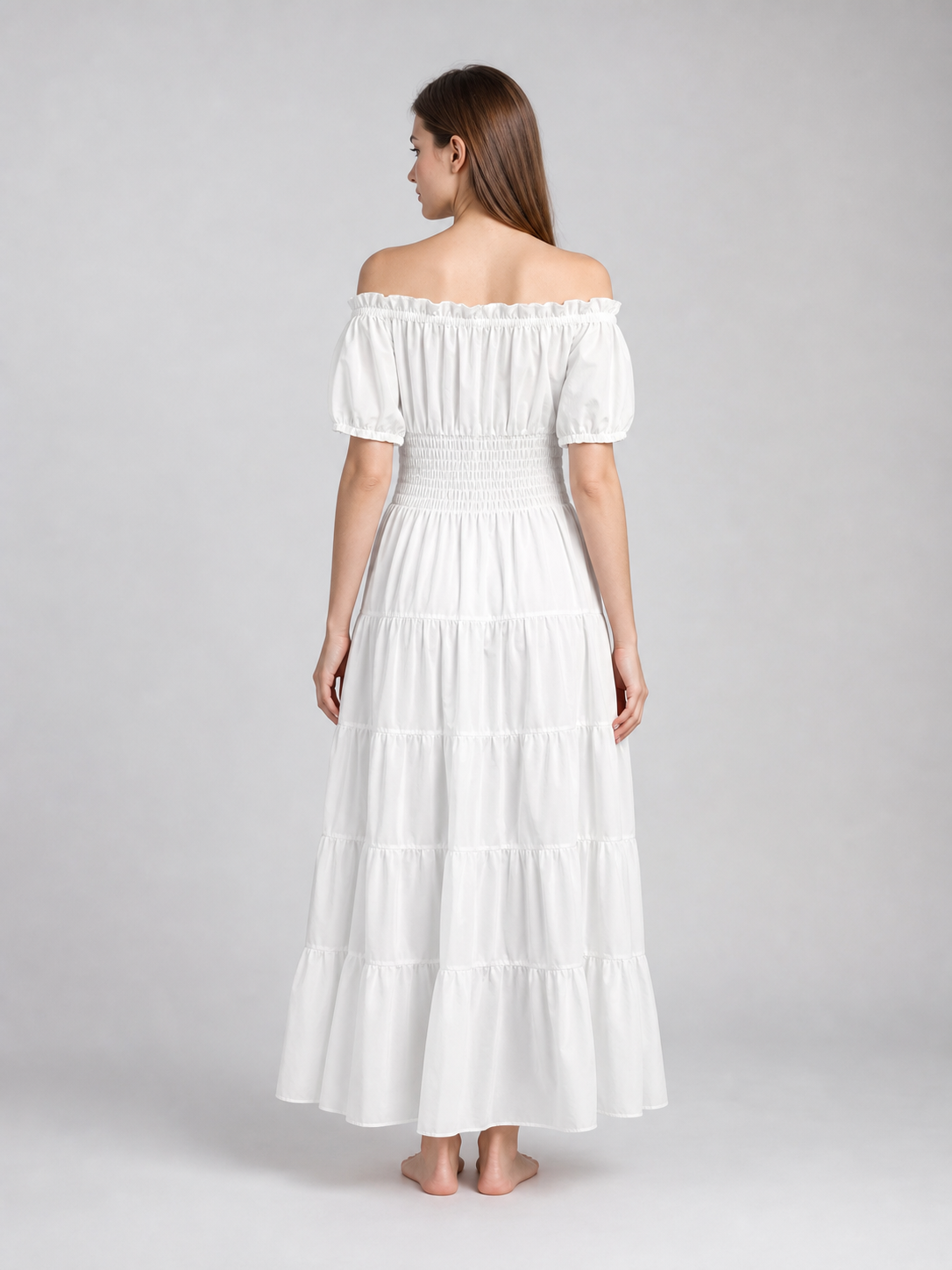 Back view of a white off-shoulder maxi dress with short puff sleeves, smocked waist, and tiered skirt on a model