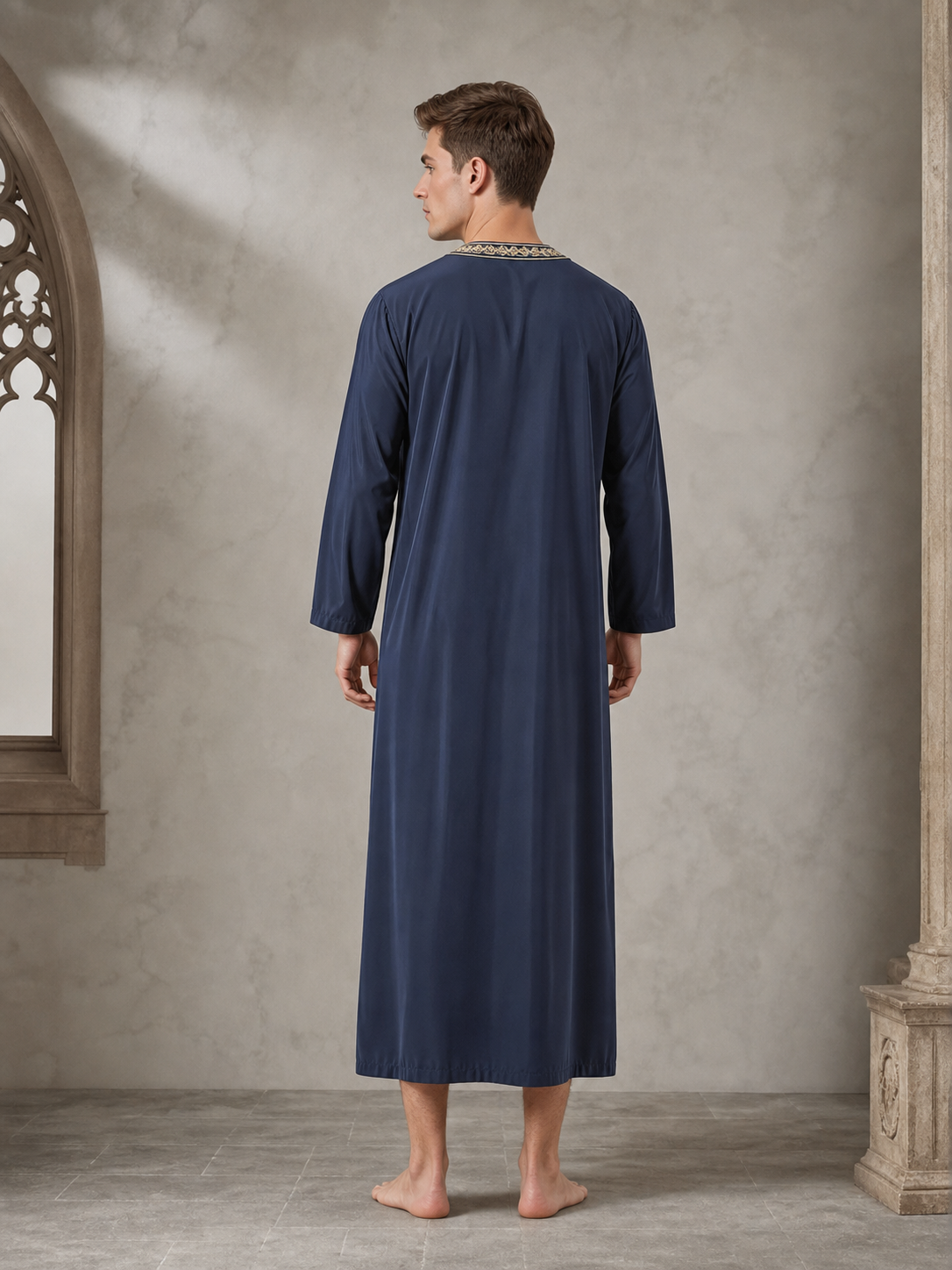 Back view of a navy blue long-sleeved robe on a model indoors, showing the straight full-length cut and embroidered trim at the collar