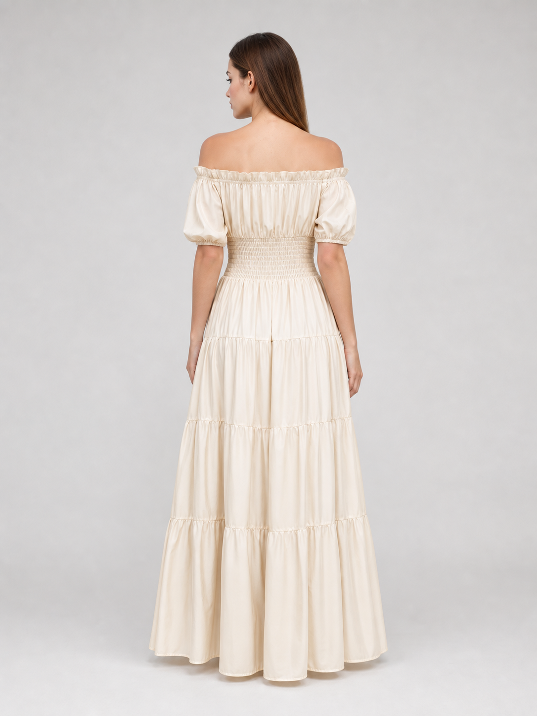 Cream off-shoulder dress with short puff sleeves, gathered waist, and tiered floor-length skirt shown from the back