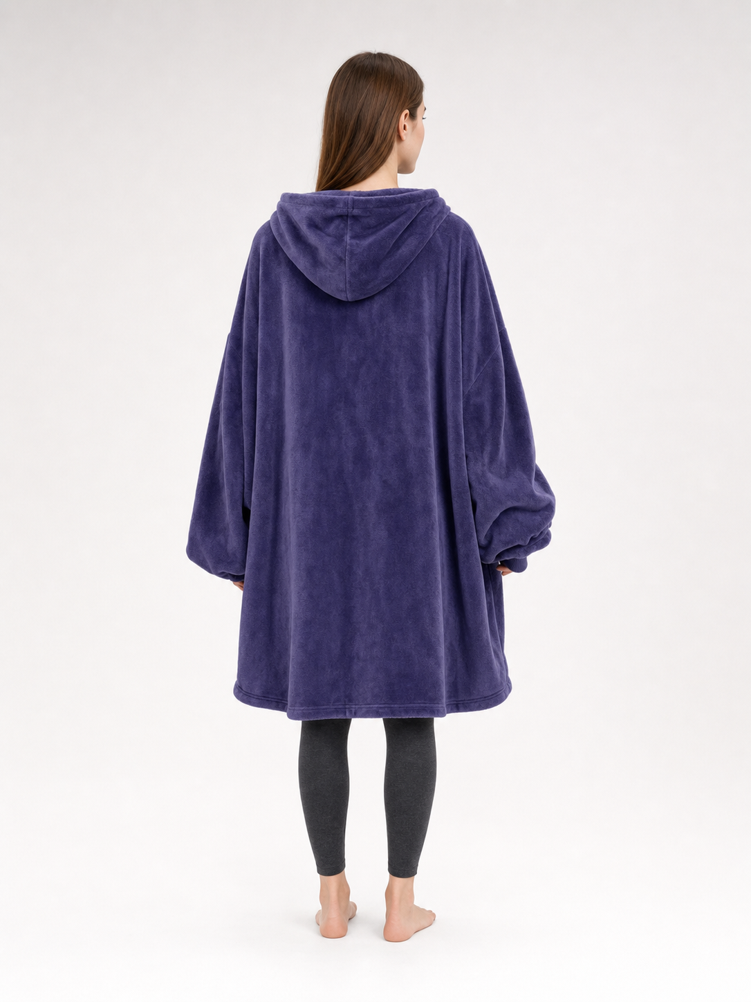 Dark purple plush hooded blanket poncho shown from the back on a model, with a hood and wide, loose silhouette