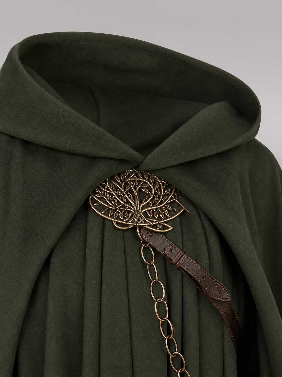 Close-up of the dark green hood and front fastening, featuring a decorative metal tree clasp, brown strap, and hanging chain