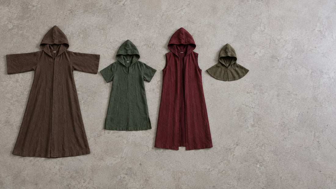 Four hooded garments laid out flat: full-length hooded robe with sleeves, knee-length hooded tunic, sleeveless hooded over-robe, and a standalone hood