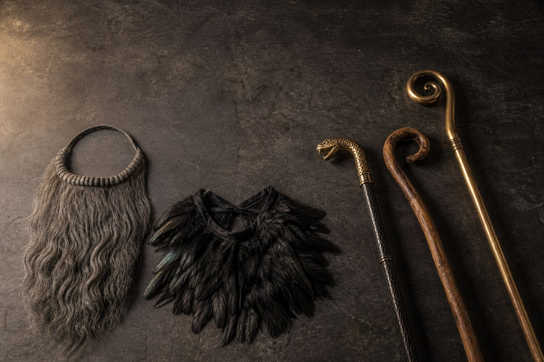 Costume beards and a feather collar laid flat on the left, canes and staffs on the right