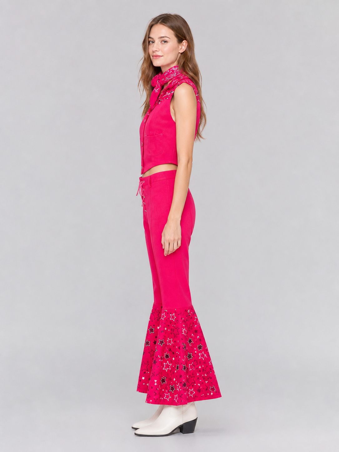 Barbie-style cosplay set consisting of two pieces: a cropped sleeveless top and flared-leg pants. The top resembles a vest with a front button closure, a decorative yoke, and a styled collar area. The pants have a high waist, front lacing, 