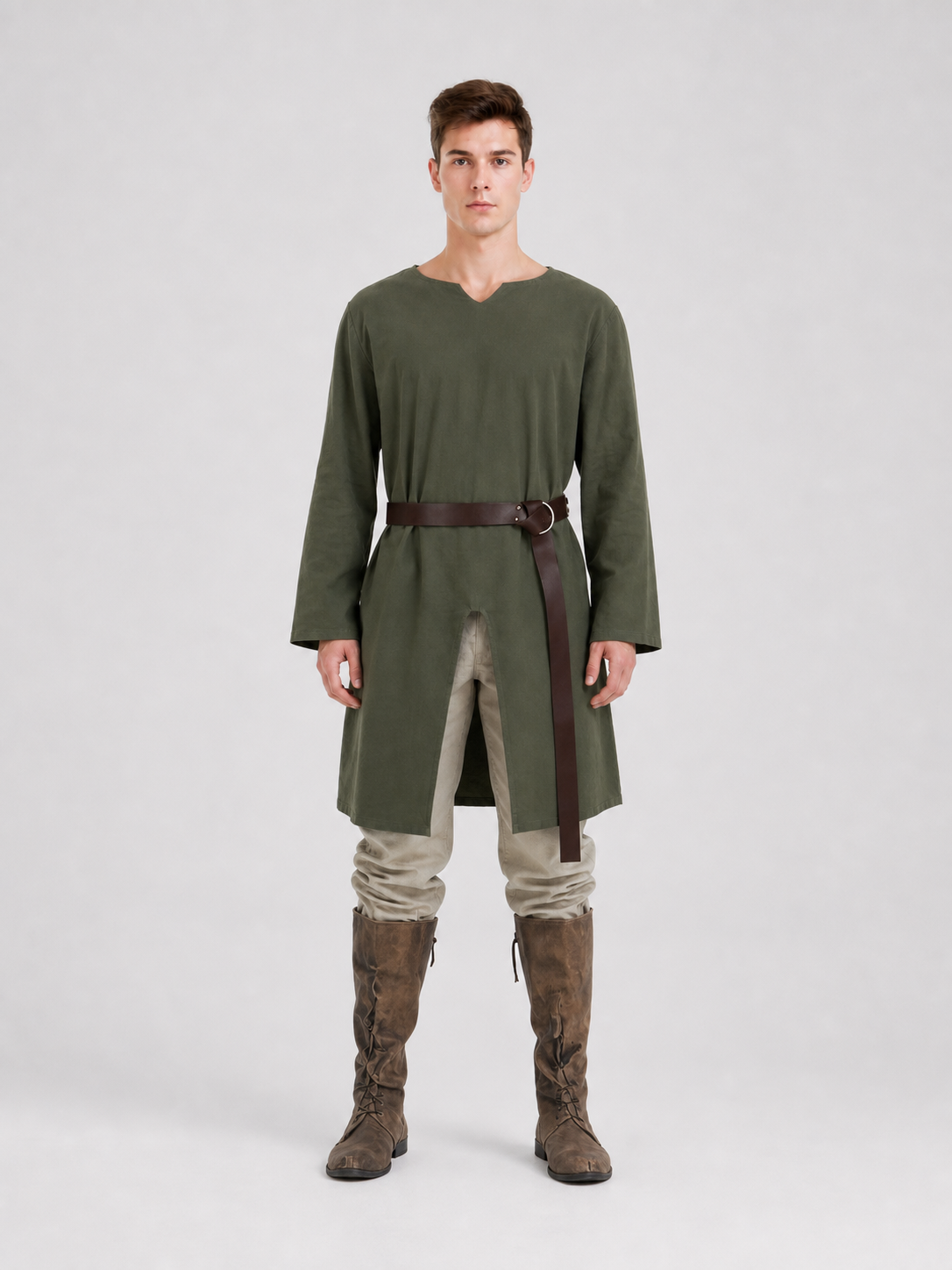Green long-sleeve tunic shown full-body on a model, with a brown ring belt, hanging strap, cream trousers, and tall brown boots