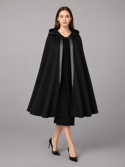 Black hooded cloak with silver patterned front trim, shown full-body on a model against a gray background