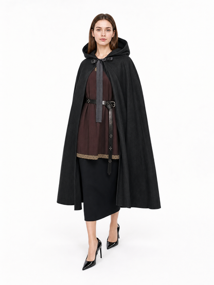 Black hooded cloak shown full-body on a model, tied at the neck with long black panels over a dark outfit