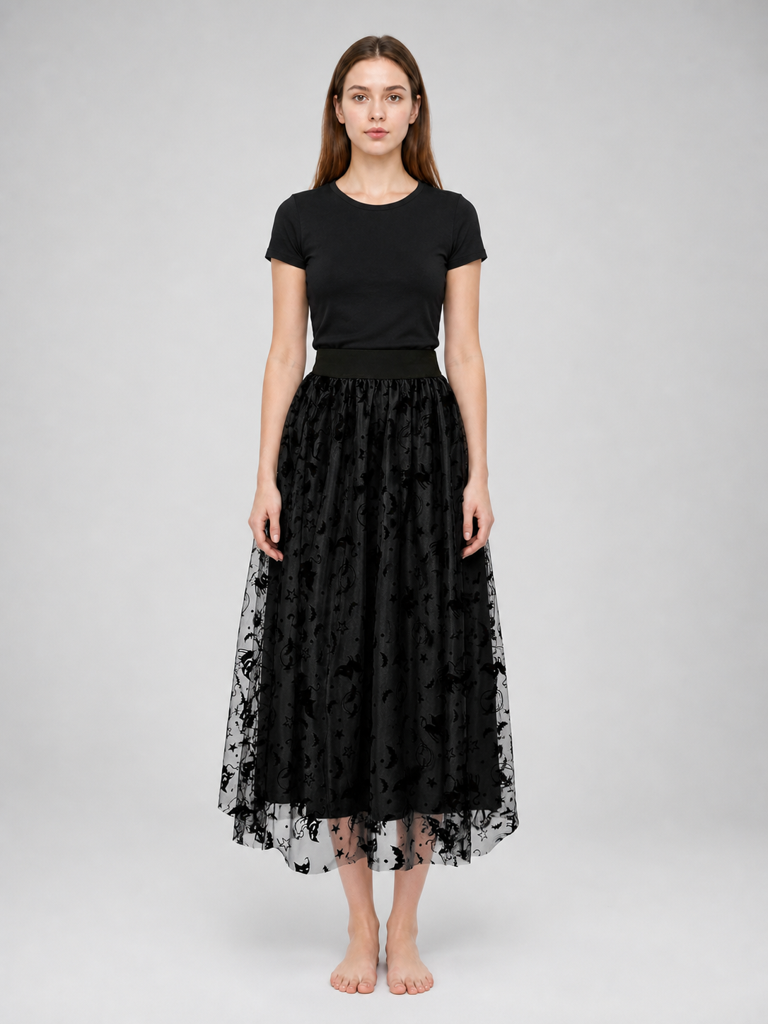 Black mesh midi skirt on a front-facing model, showing the gathered waistband, layered construction, and sheer motif-covered lower hem