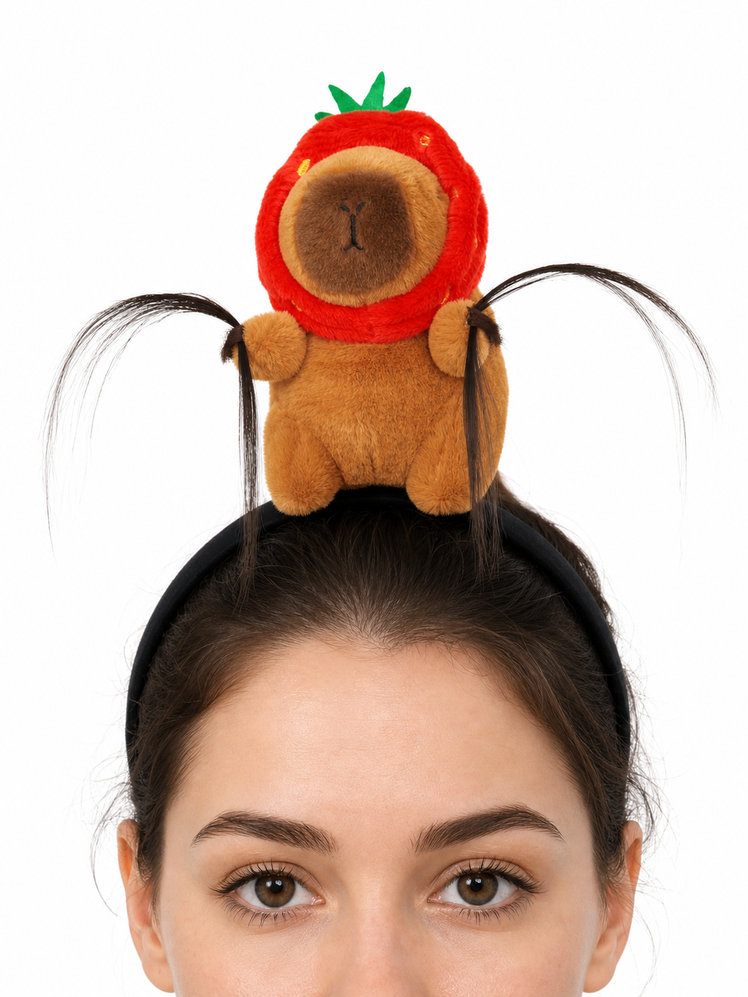Close-up of a black headband with a plush brown animal, red strawberry hood, green leaves, and long black decorative strands
