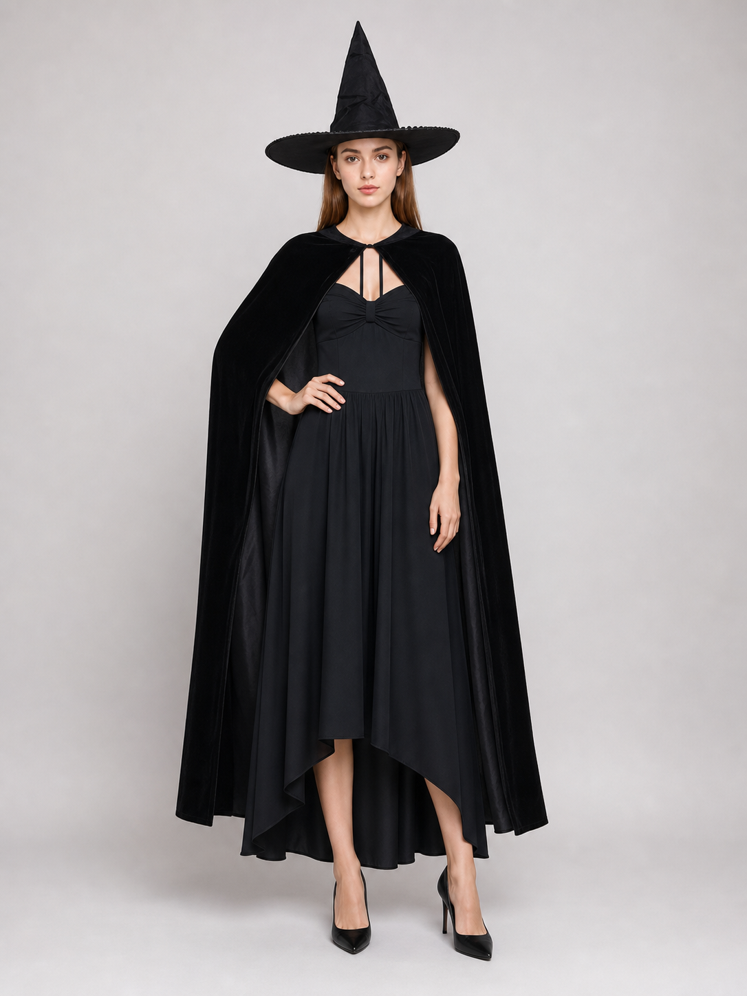 Black costume cape on a full-body model, draped over a black dress with a pointed witch hat and black heels