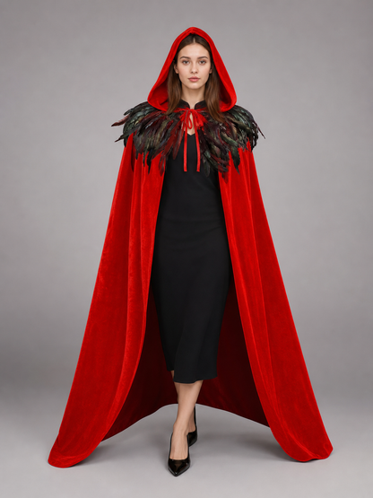 Front view of a red velvet-look hooded cape with black feather trim and tie closures on a model