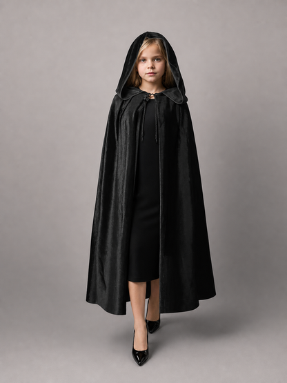 Black hooded cape with a glossy fabric look, shown full-body on a child model with front tie cords