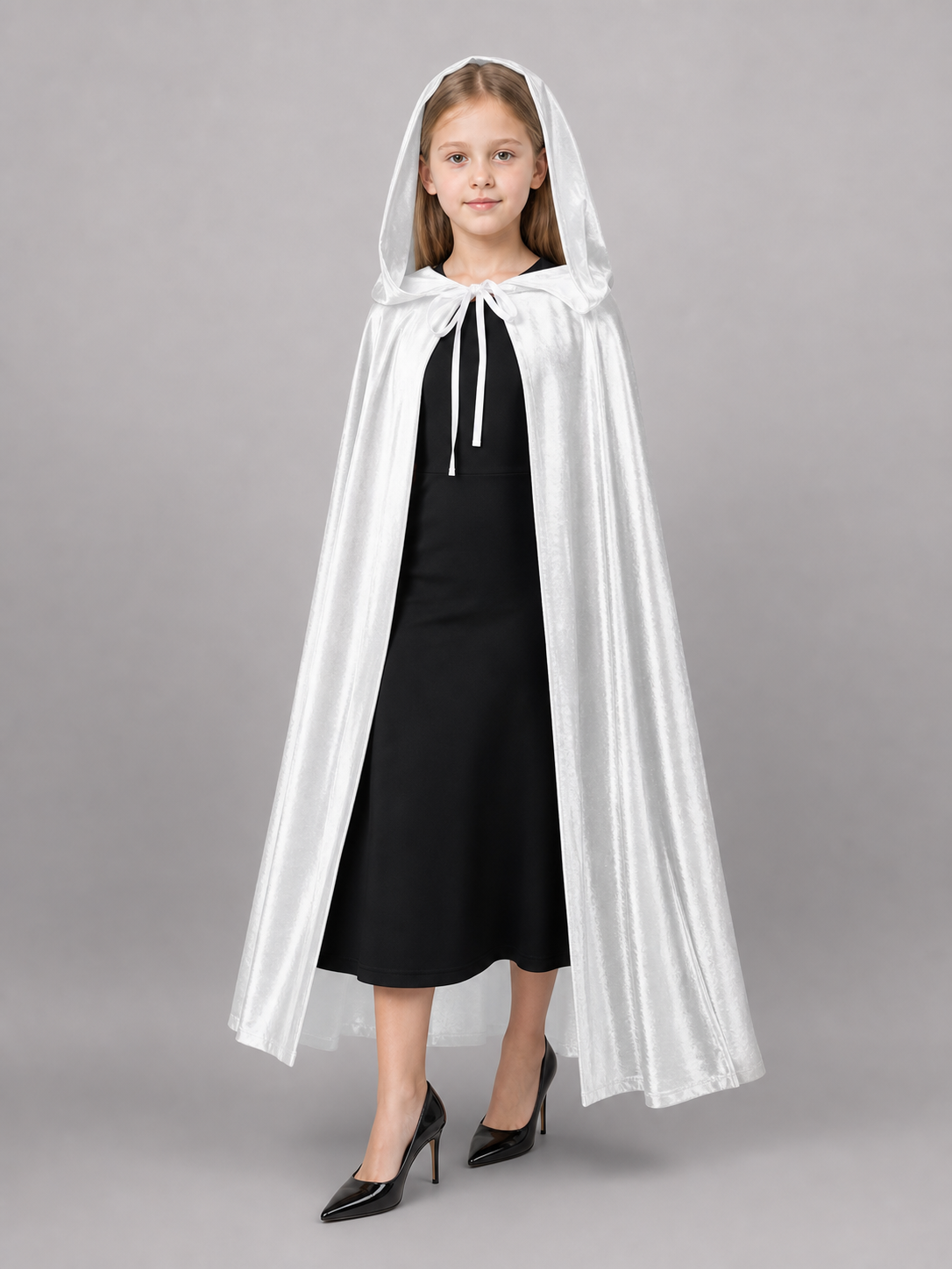 White hooded costume cape with long front ties, shown full-body on a child over a black dress against a gray background
