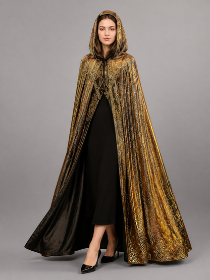 Front view of a model in a gold hooded cape with black lining, draped over a black dress