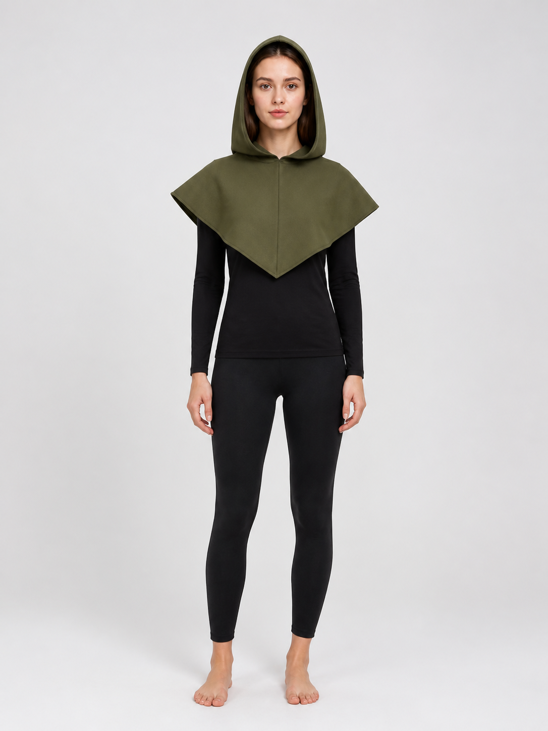Full-body front view of a model wearing an olive green hooded cape over a black long-sleeve top and leggings