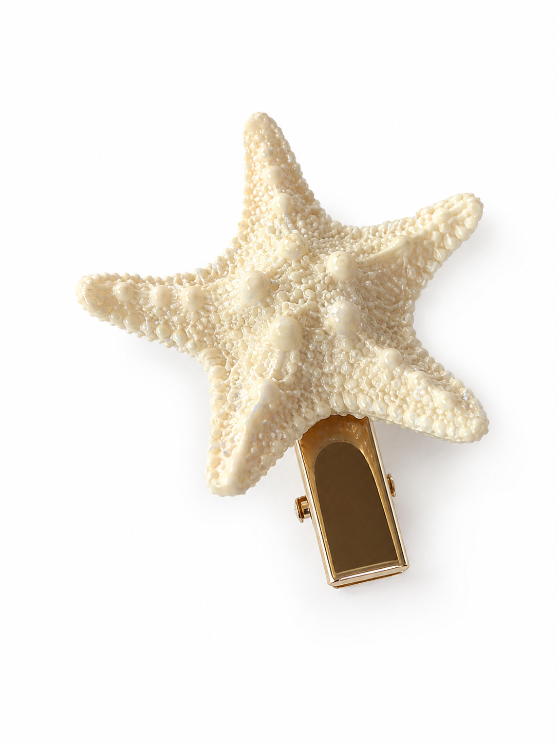 Starfish hair clip with a cream textured surface and gold-tone clasp, shown close up on a white background