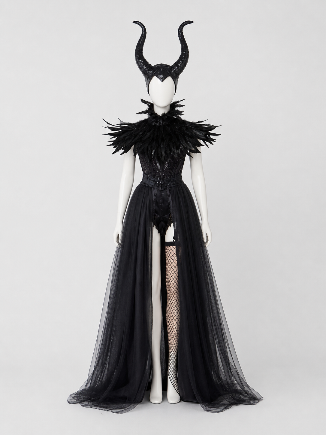 Full-body mannequin wearing a black costume with curved horns, feathered collar, fitted bodice, sheer split overskirt, and fishnet stocking
