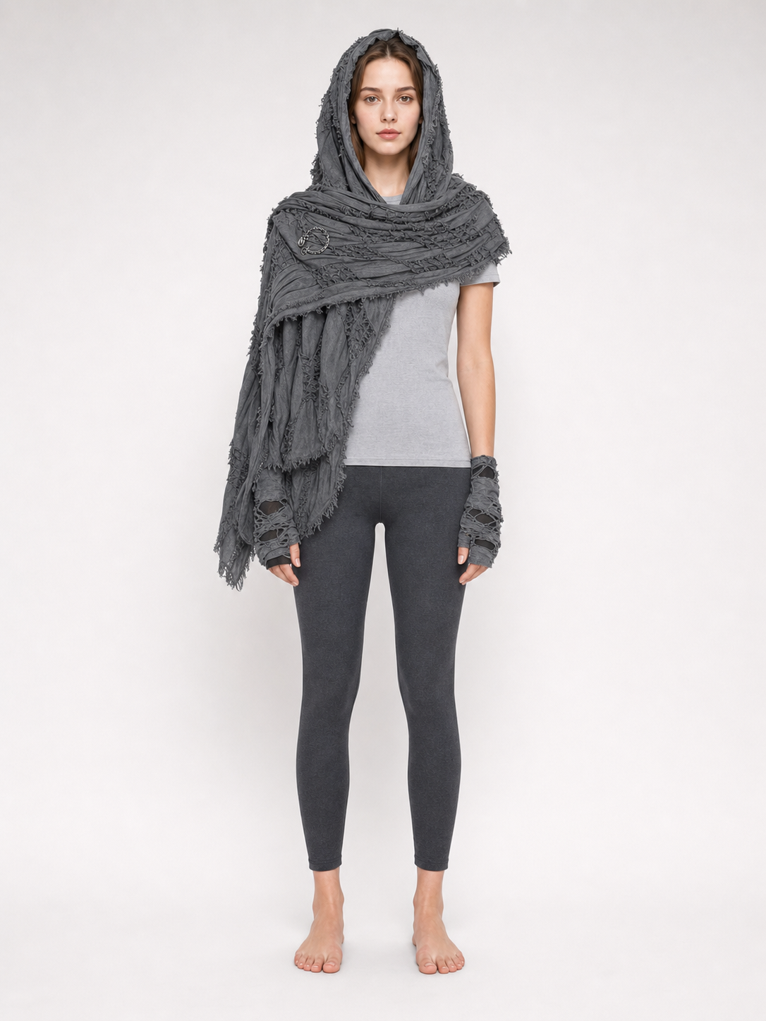 Gray hooded scarf with matching fingerless gloves and fringed edges, shown full-body from the front on a model