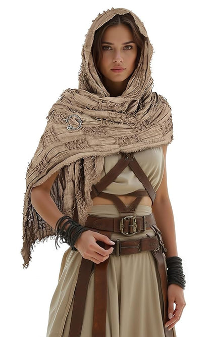 Khaki hooded scarf cape with fringed edges, textured woven fabric, and a decorative ring detail on a full-body model