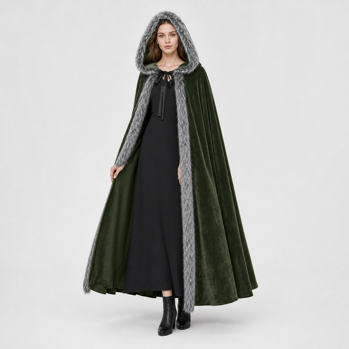 Olive green velvet-look hooded cape with gray faux-fur trim, shown full-length on a model over a black dress