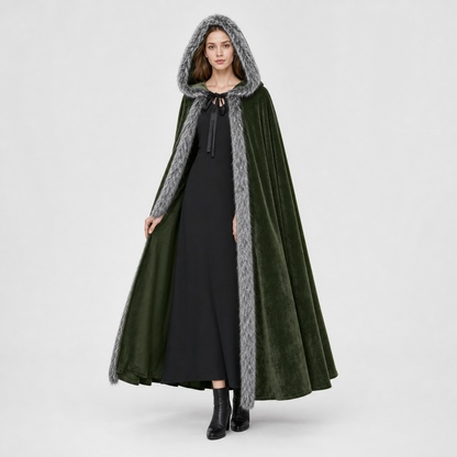 Olive green velvet-look hooded cape with gray faux-fur trim, shown full-length on a model over a black dress