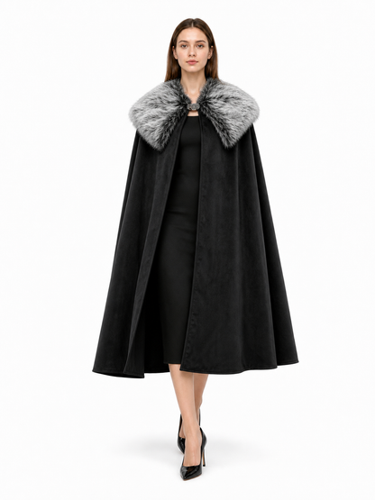 Black cloak with a wide gray faux fur collar and front clasp, shown full-length on a model in a white studio