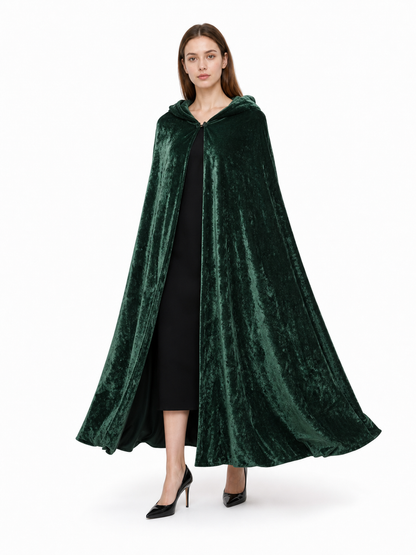 Dark green hooded velvet-look cape shown on a walking model, open at the front over a black dress