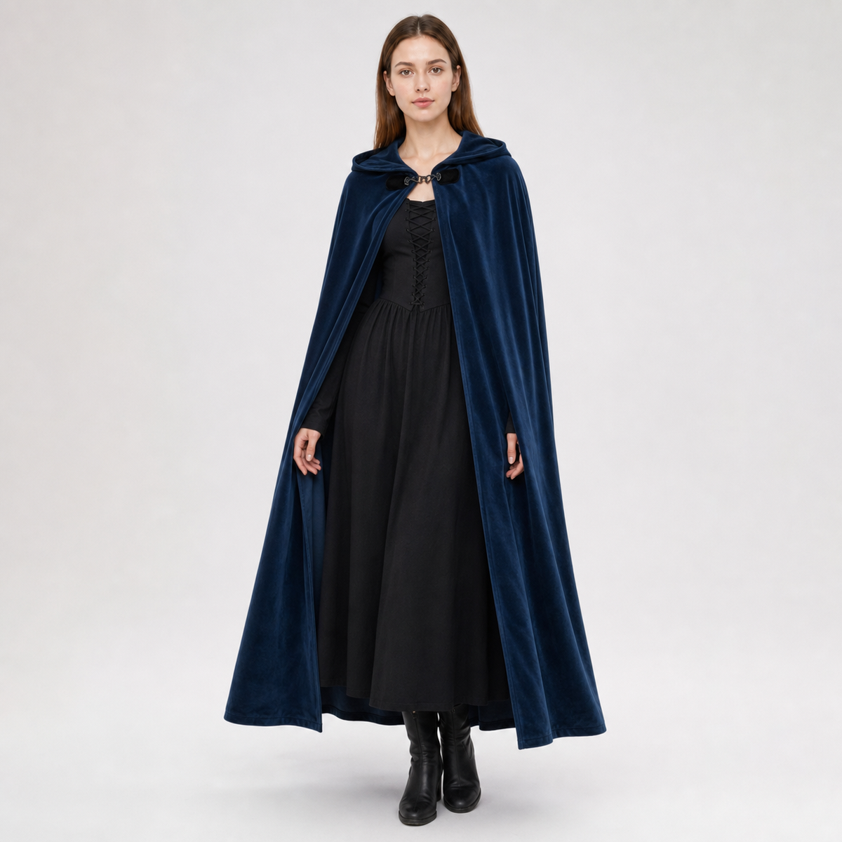 Navy hooded cape with a front clasp, worn full-length over a black dress by a standing model