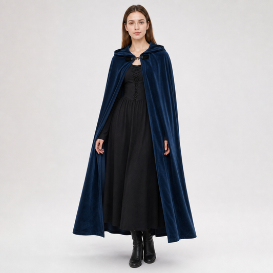 Navy hooded cape with a front clasp, worn full-length over a black dress by a standing model