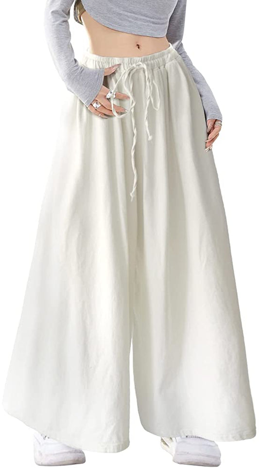 White wide-leg pants shown from the waist down on a model, with a gathered drawstring waistband and flowing fabric