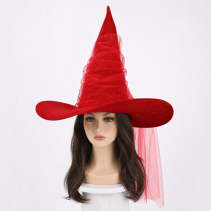 Red pointed witch hat on a mannequin, with a wide curved brim, sheer layered cone, glitter specks, and a long veil