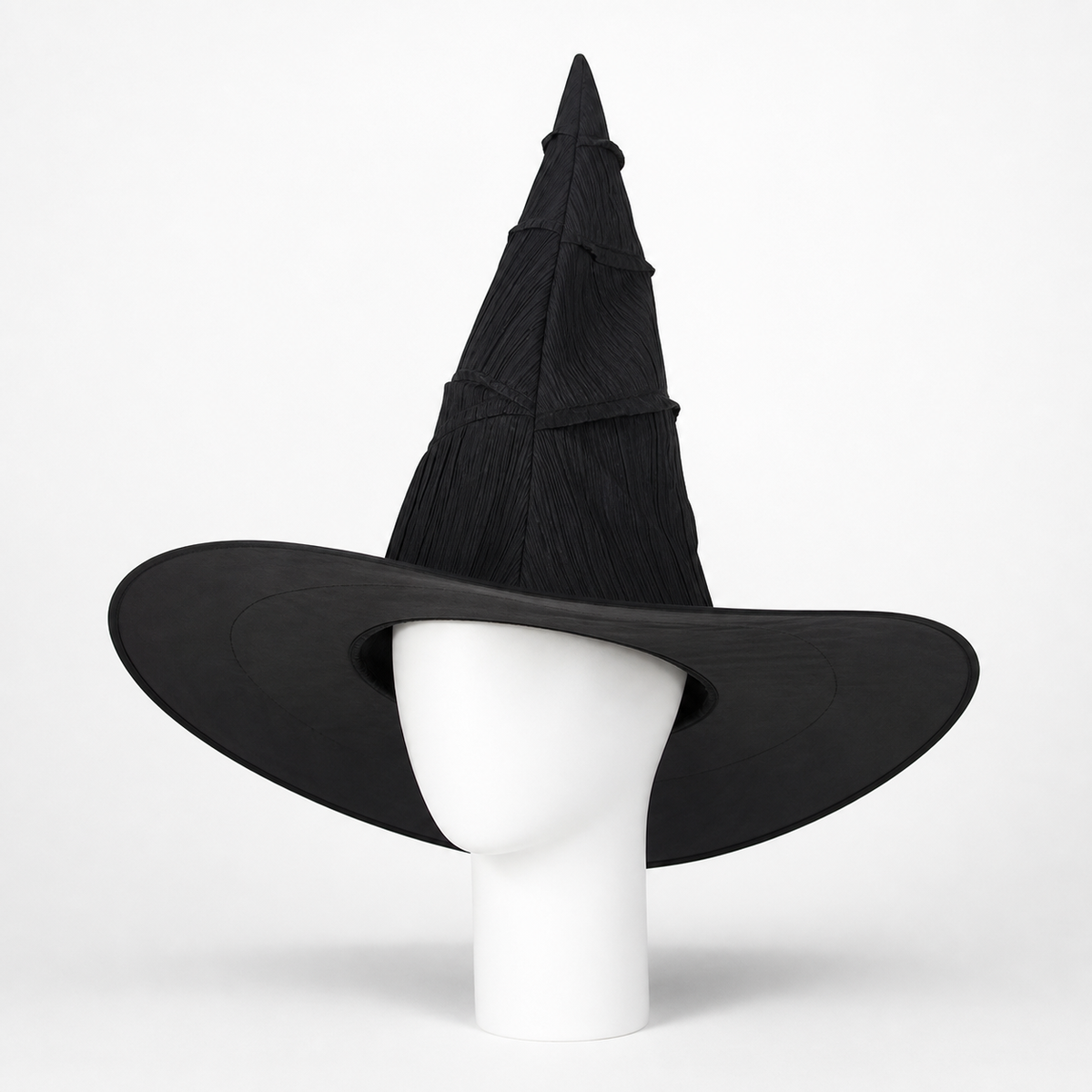 Black pointed witch hat with a wide curved brim displayed on a white mannequin head