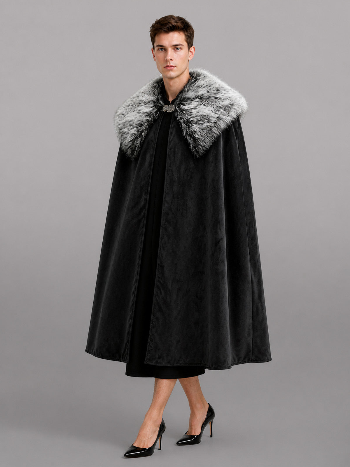 Black velvet-look cape with a gray faux fur collar and front clasp, shown full-length on a model