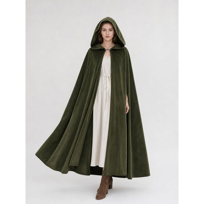 Dark olive green hooded cloak on a full-body female model, worn over a white dress with the front opening and clasp visible