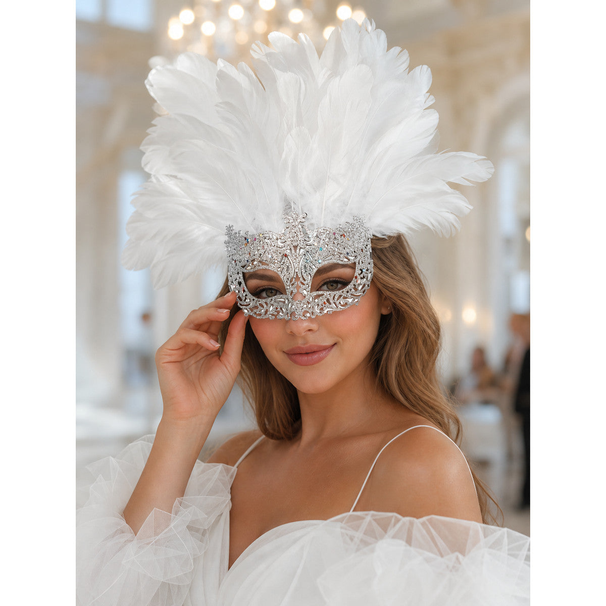 White feather masquerade mask with a silver-tone decorative frame, shown on a model in a bright indoor setting