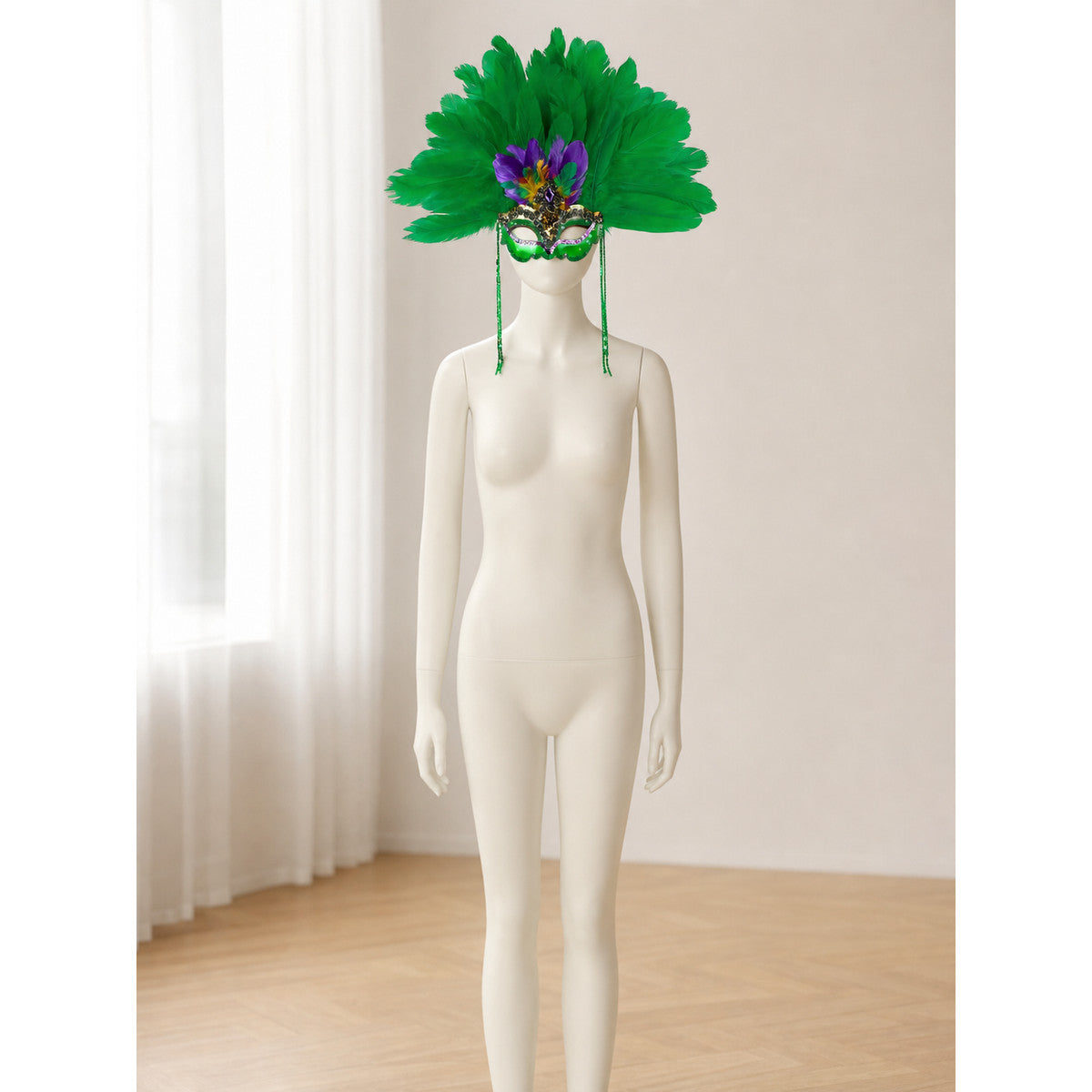 Green feather eye mask with long green side strands displayed on a full-body white mannequin in a bright room
