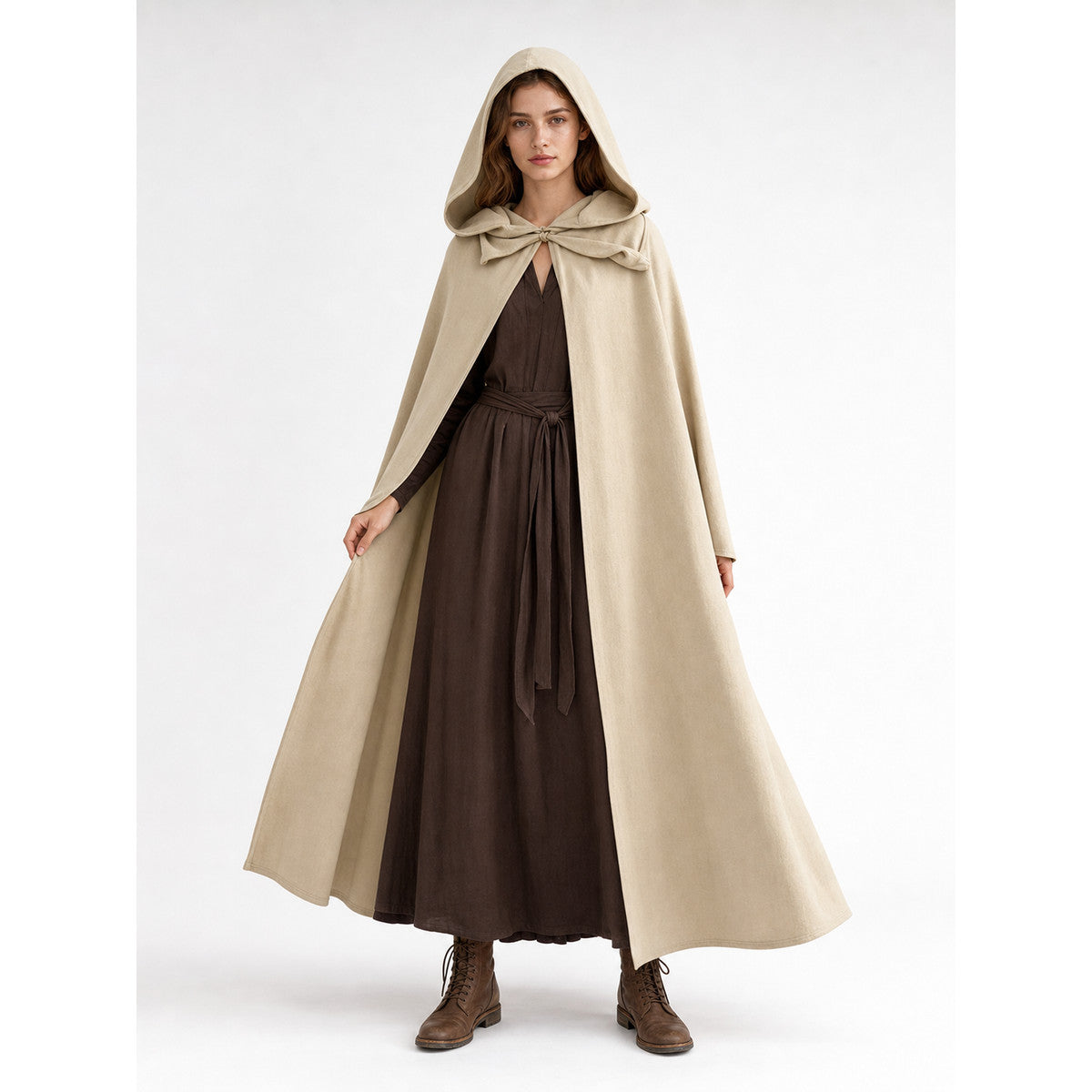Beige hooded cape shown full-length on a woman, worn over a dark brown dress with a draped front and wide flowing hem