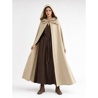 Beige hooded cape shown full-length on a woman, worn over a dark brown dress with a draped front and wide flowing hem