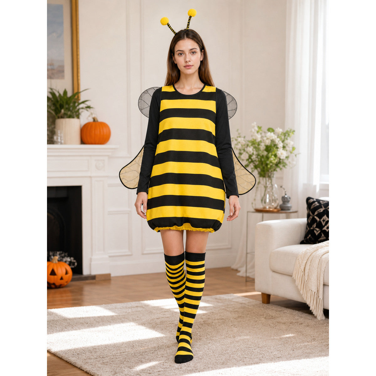 Full-body view of a black and yellow striped costume with antennae and translucent wings, styled in a living room