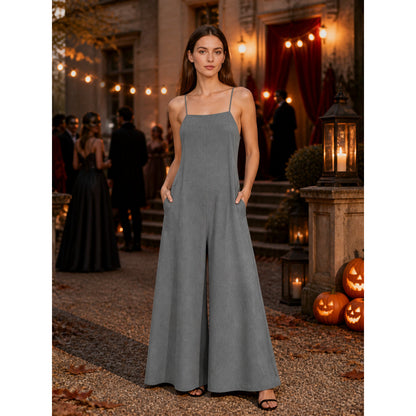 Gray wide-leg jumpsuit with thin straps and side pockets, shown full-length on a model outdoors near pumpkins and lanterns
