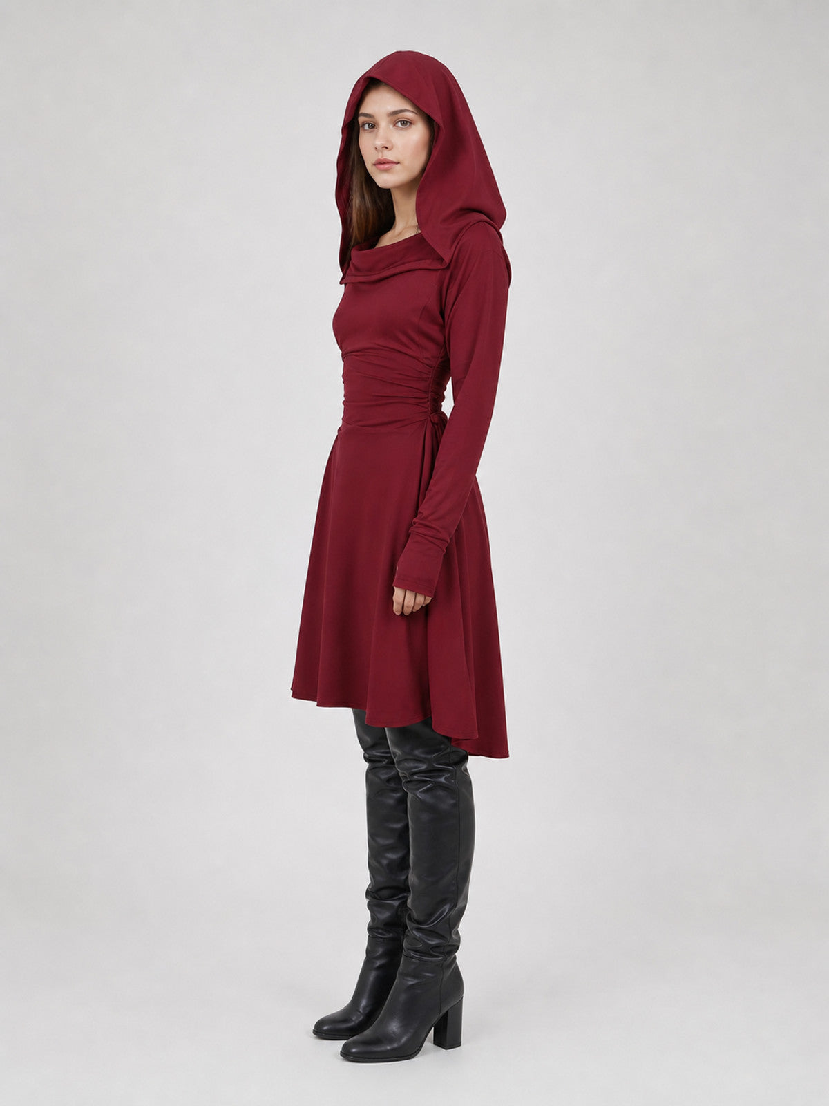 Burgundy hooded tunic in smooth fabric, shown in side view on a model with the hood raised, long sleeves, and an uneven hem