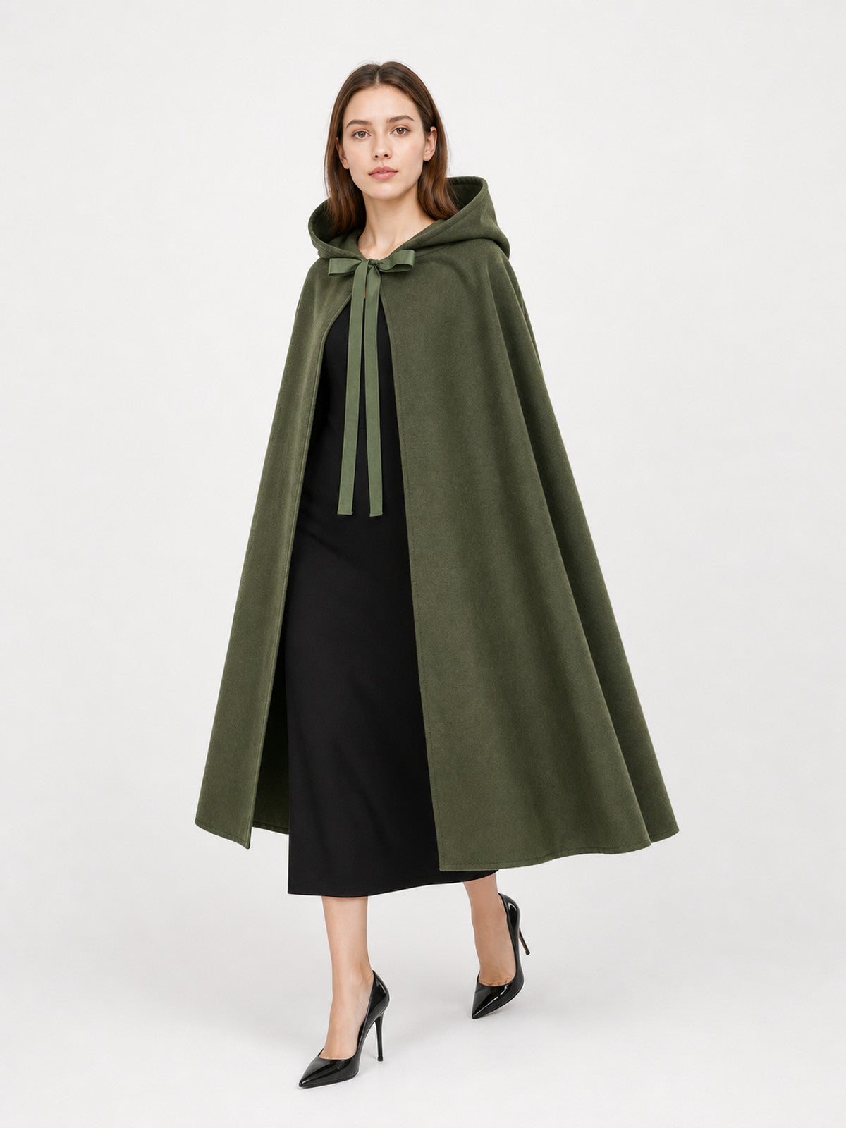 Olive green hooded cape with a soft suede-like texture and front tie ribbons, shown on a model from a three-quarter angle