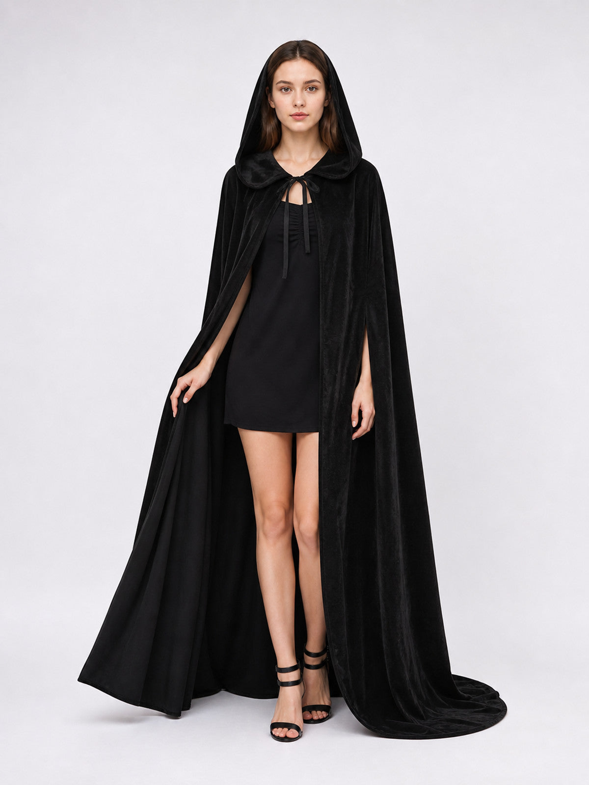 Black hooded cape shown full length on a model, with a tied neckline, open front, and draped trailing sides