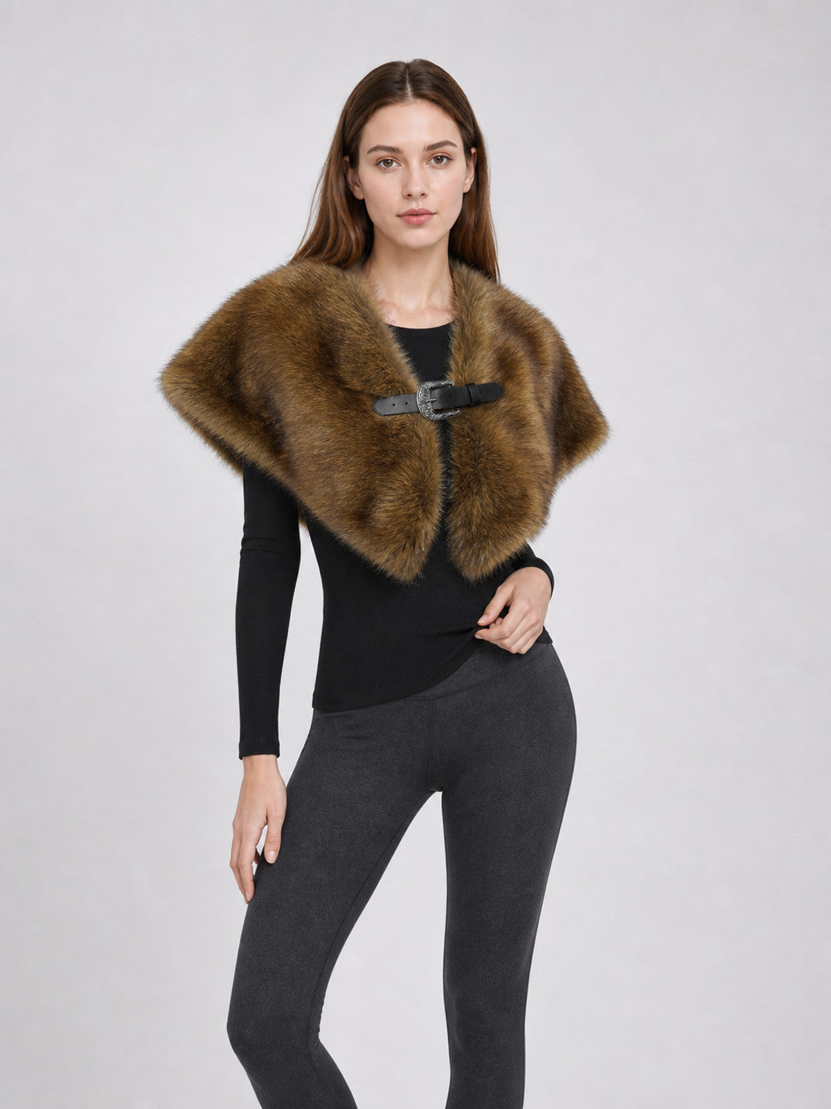 Brown long-pile shoulder cape styled over black clothing on a model, shown in a three-quarter view with a front buckle
