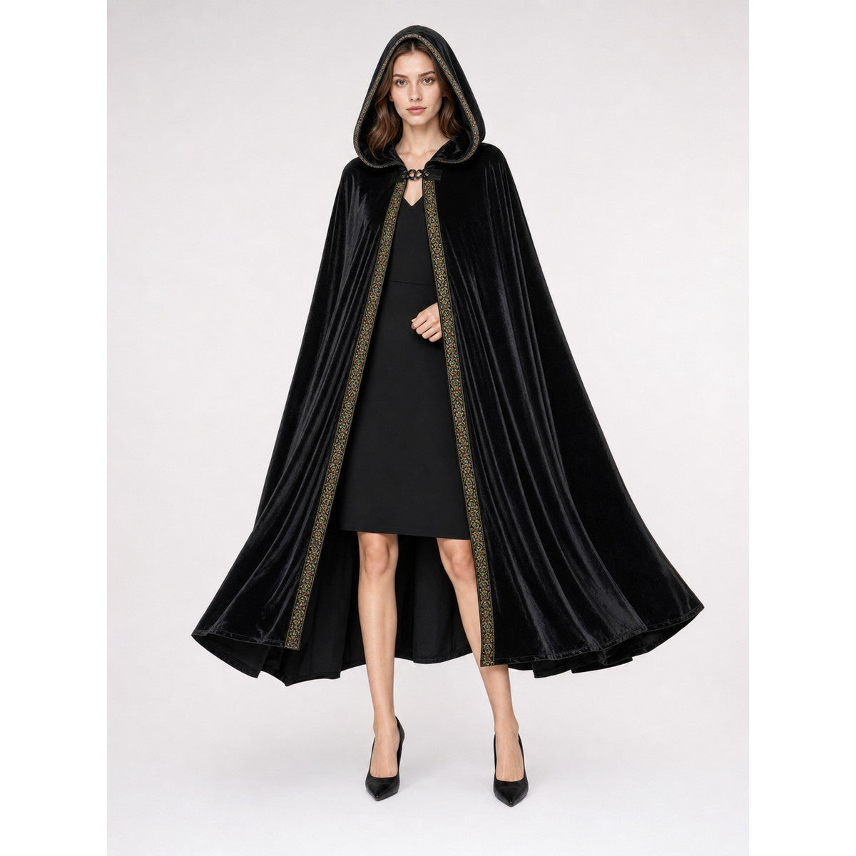 Black hooded cloak shown full-body on a model, with a flared drape, glossy velvet-look fabric, and decorative front trim