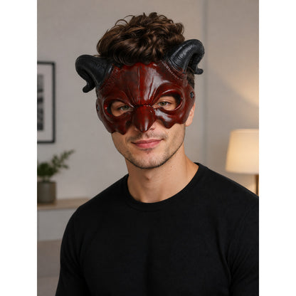 Horned carnival mask in glossy dark red with black curled horns, worn by a male model in a black shirt indoors