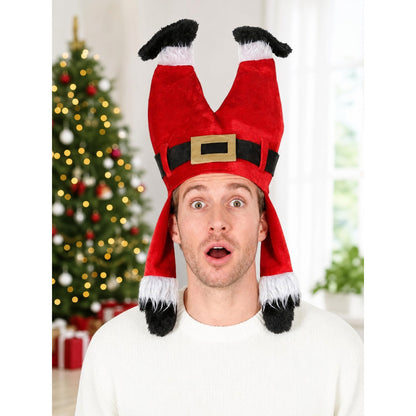 Red plush costume hat modeled from the front with black and white fuzzy trim and a gold buckle, shown in a Christmas-decorated room