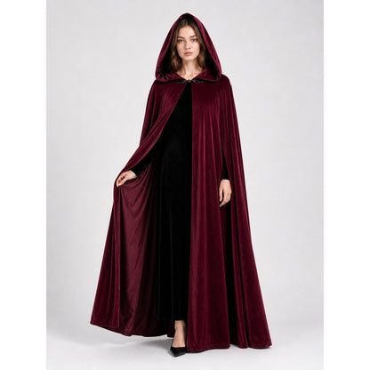 Full-body female model wearing a burgundy velvet-textured hooded cape, holding the open front to show the black outfit underneath